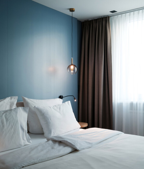 Schlafzimmer des Henriette Longstay Circular Living Deluxe Apartments mit Balkon in Wien.