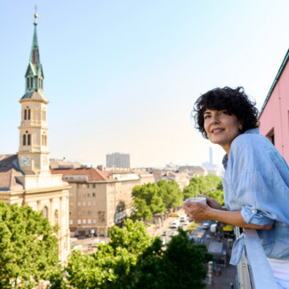 Frau am Balkon ihres Zimmers im Henriette Stadthotel Vienna mit Blick über die Praterstraße, Wien.